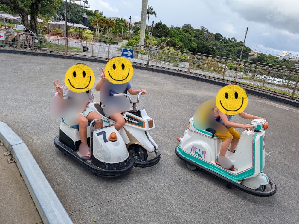 沖縄こどもの国のライドパークで、ミニカーに乗って遊ぶ子どもたち