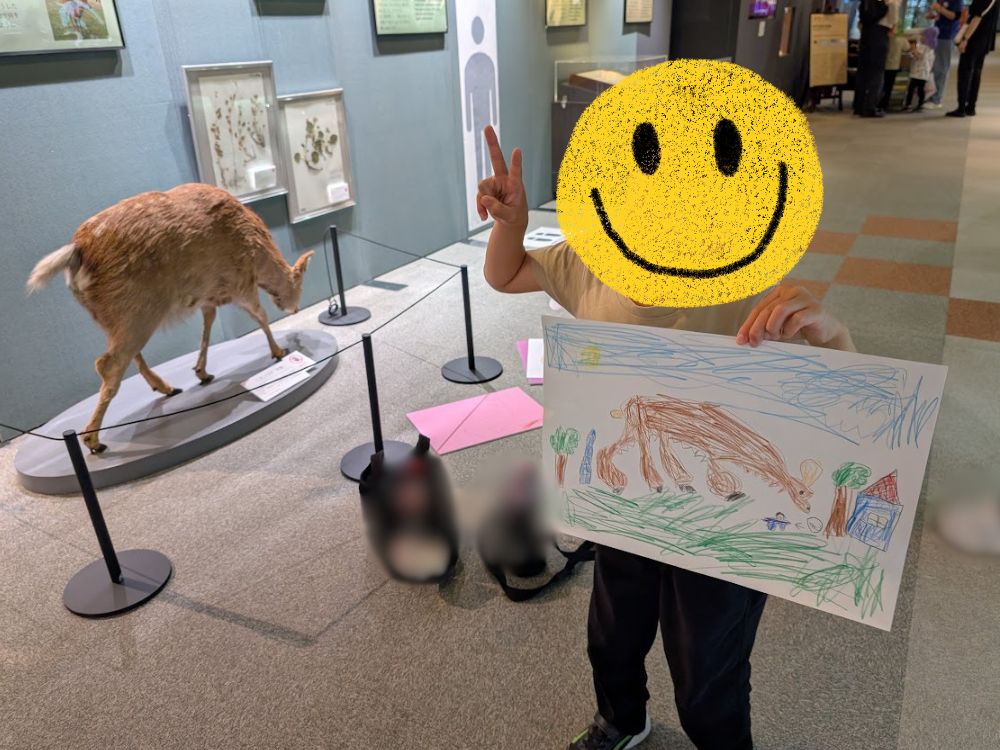 ひとはくのお絵描きイベントで描いた絵を持っている子ども